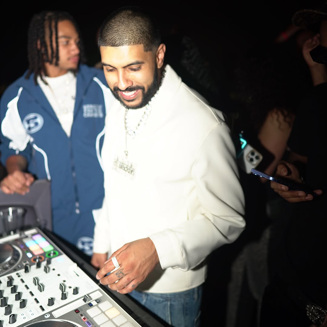 DJ Aladdinn with both hands on the mixer and controller mid-mix